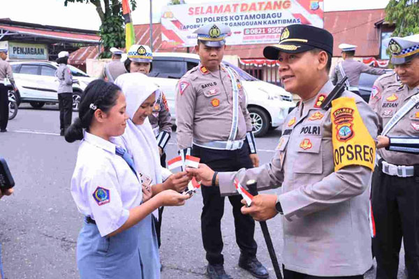 Polres Kotamobagu membagikan bendera dan pita merah putih secara gratis kepada warga masyarakat, (12/8/2024)