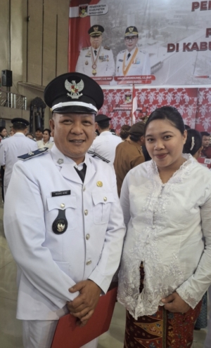 Richard Mewo didampingi istri usai dilantik dan diambil sumpah sebagai Hukum Tua Desa Rambunan Amian oleh Bupati Minahasa Dr. Robby Dondokambey, S.Si., MAP di Gedung Wale Ne Tou, Tondano, Selasa (14/7/2026).
